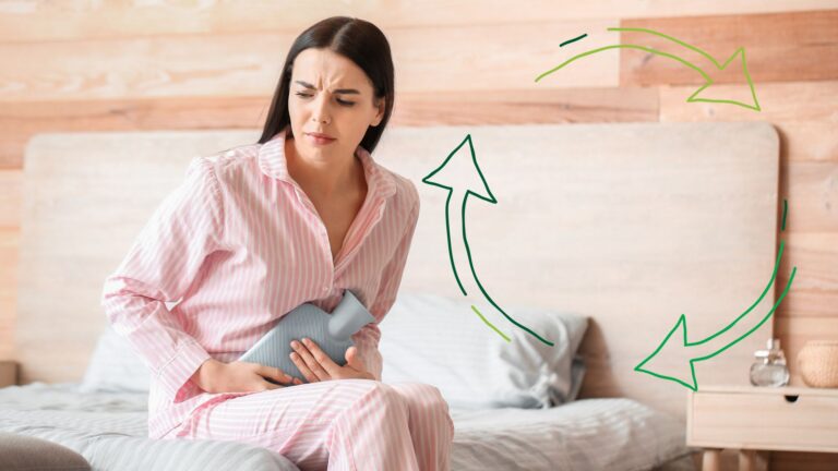 A woman experiencing menstrual pain on her bed.