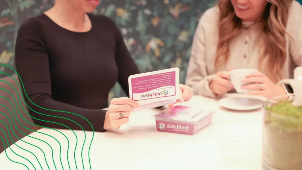 A menopausal doctor showing her patient a hormone test kit